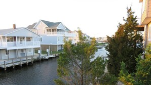 A waterfront property with multiple houses connected by a dock, a wooden fence, and a river.