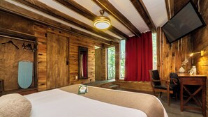 Une pièce aménagée comme un chalet en bois, avec un lit, un bureau et un téléviseur.