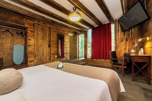 Une pièce aménagée comme un chalet en bois, avec un lit, un bureau et un téléviseur.