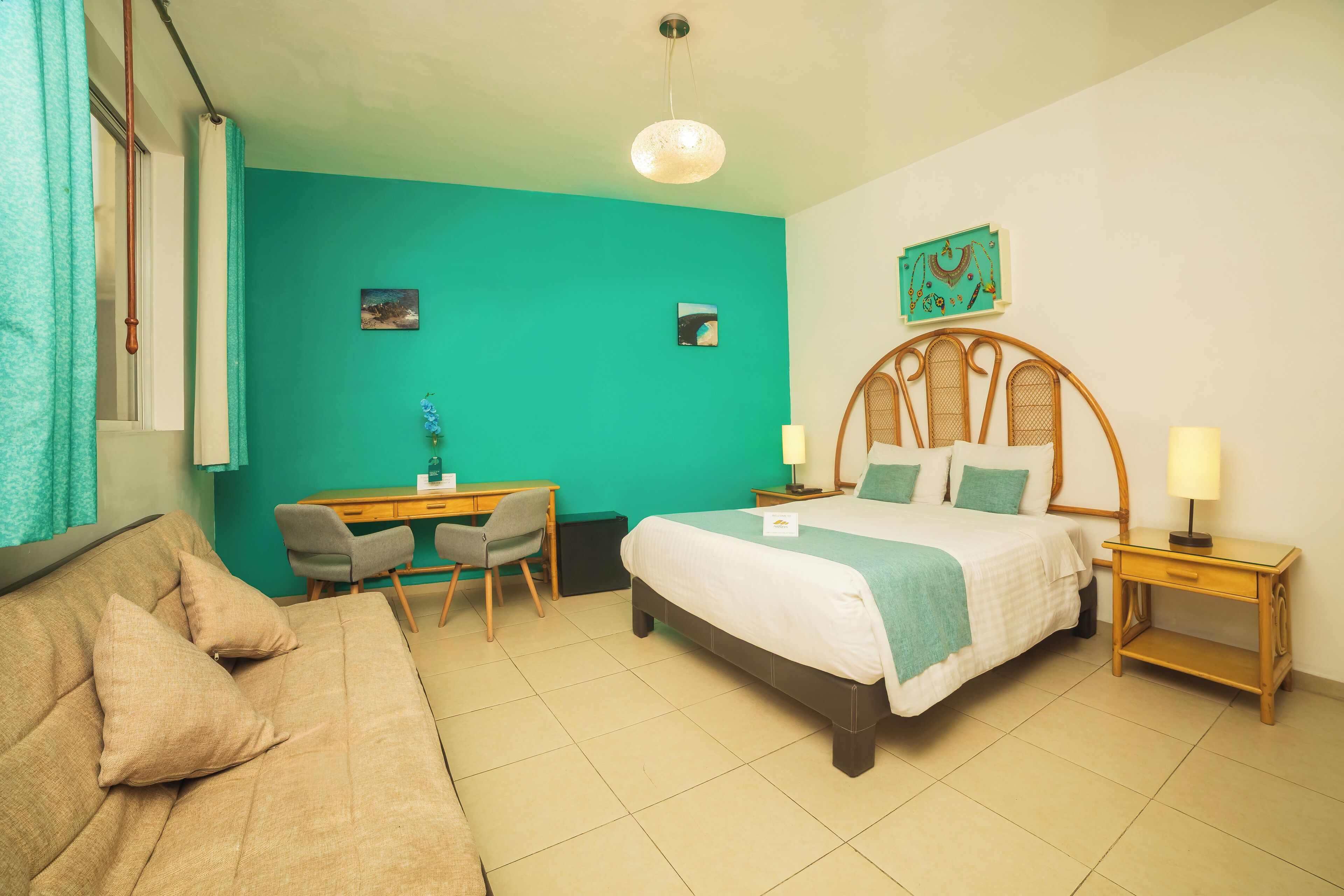 Un dormitorio con cama, escritorio, silla y una mesita con lámparas.
