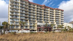 Un hotel de varios pisos con múltiples balcones y una entrada principal.