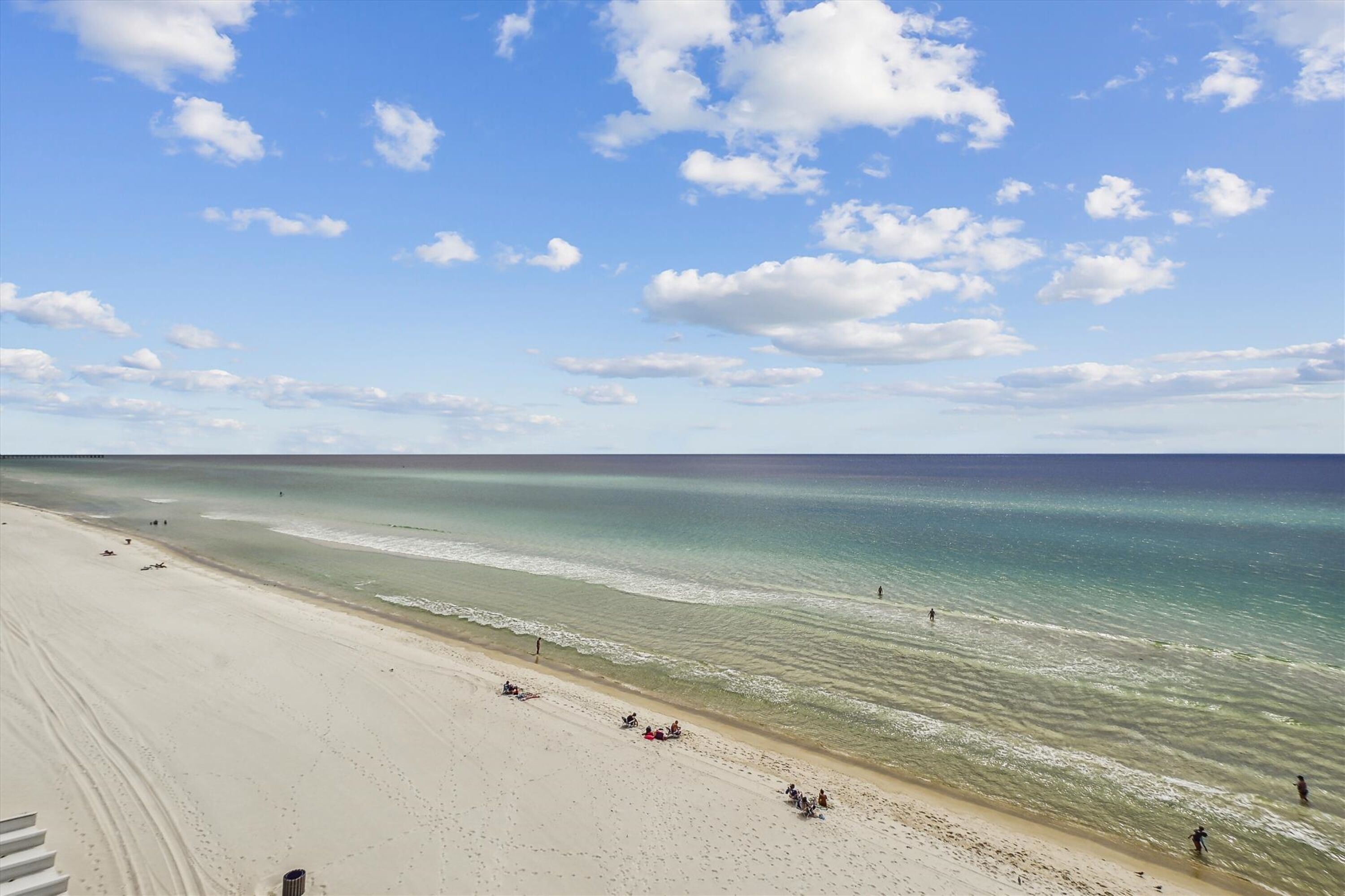 Une plage avec un ciel dégagé et une mer calme.