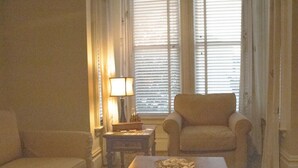 Ein Wohnzimmer mit Sofa, Sessel, Couchtisch und Lampe.