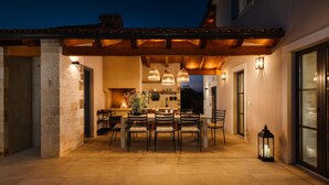An outdoor patio with a wooden pergola, a dining table with chairs, and a stone wall. - Awesome home in Tinjan (Tinjan)