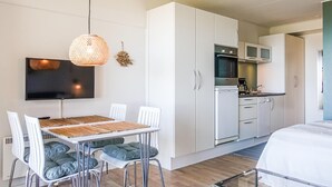 A modern kitchen with white cabinets, a built-in oven, and a coffee maker. - Awesome apartment in Allinge (Allinge)