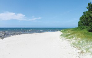A sandy beach with scattered rocks and a clear blue sky. - Amazing apartment in Nexø with sauna (Nexø)