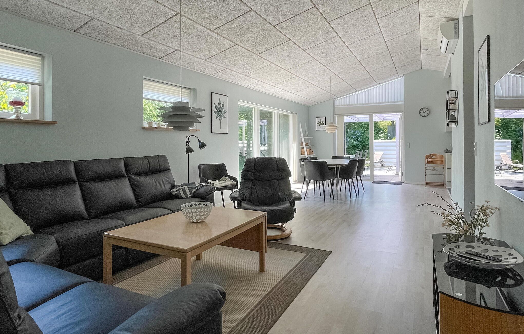 Ein modernes Wohnzimmer mit einer Couch, einem Couchtisch und einem Essbereich mit Stühlen und einem Tisch.