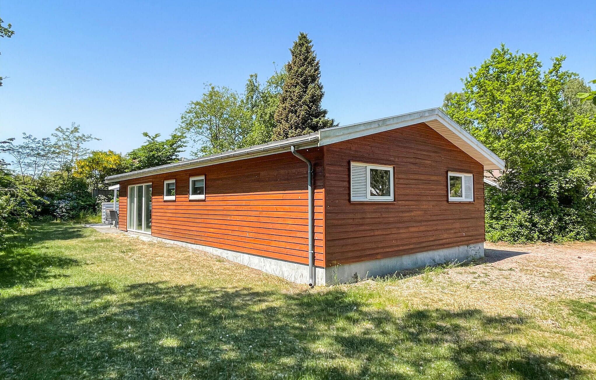 A small, single-story wooden cabin with a sloped roof, a front door, and a small porch area.