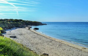 A pebbly beach with a grassy cliff and a clear blue sky. - 3 bedroom awesome home in Moelan sur Mer (Moelan sur Mer)