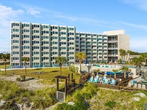 A multi-story hotel with a pool area and outdoor seating. - Tootsie's Next Door! Top of The Gulf! (Panama City Beach)