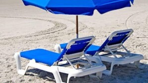 A beach with two white lounge chairs and a blue umbrella. - Tootsie's Next Door! Top of The Gulf! (Panama City Beach)
