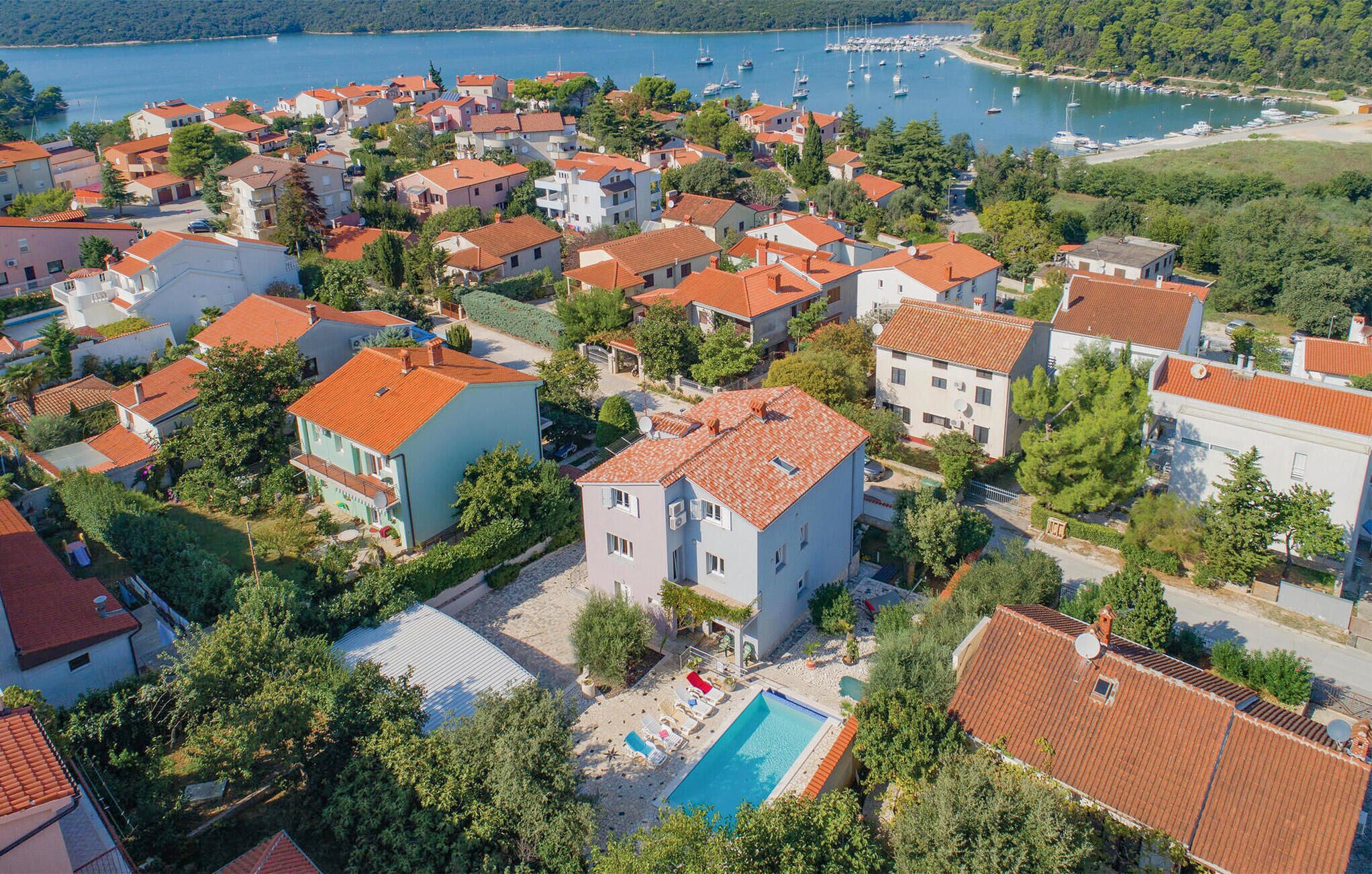 A residential area with houses, a swimming pool, and a marina with boats.