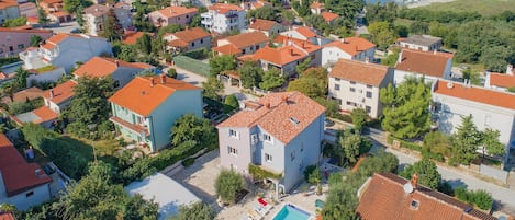 A residential area with houses, a swimming pool, and a marina with boats.