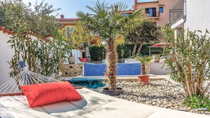 A sunlit outdoor area with a hammock, a small pool, and various potted plants. - 1 bedroom nice apartment in Banjole (Banjole)