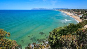 A coastal view with clear turquoise waters, a sandy beach, and a town in the background. - Nice apartment in Alcamo Marina with WiFi (Alcamo Marina)