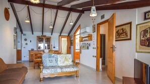 A spacious living room with a sofa, wooden furniture, and a dining area with a cabinet and chairs. - Nice apartment in Alcamo Marina with WiFi (Alcamo Marina)