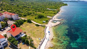 An aerial view of a coastal area with a beach, clear blue sea, and lush greenery. - 2 bedroom gorgeous apartment in Dobropoljana (Dobropoljana)