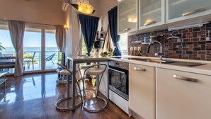 A modern kitchen with a view of the sea, a dining area with a view, and a bar area with stools. - 2 bedroom gorgeous apartment in Dobropoljana (Dobropoljana)