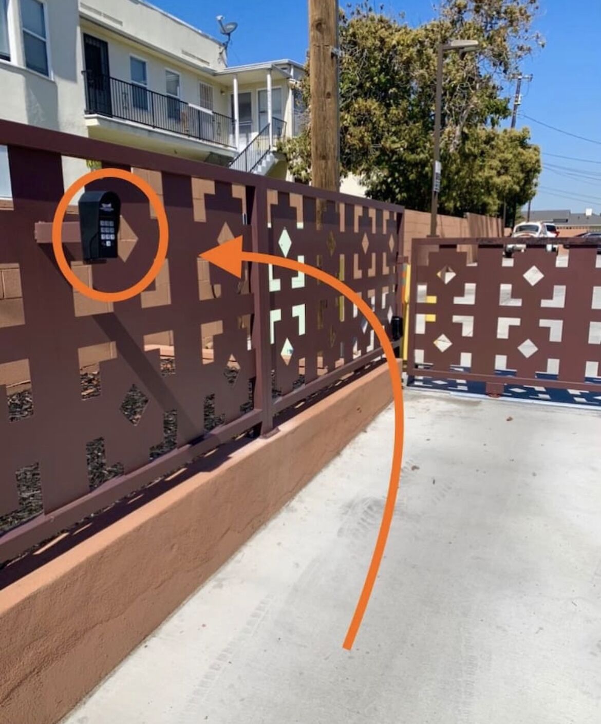 A gated area with a brown fence and a security camera.