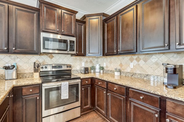 Fully equipped kitchen with double oven, microwave, and coffee maker.