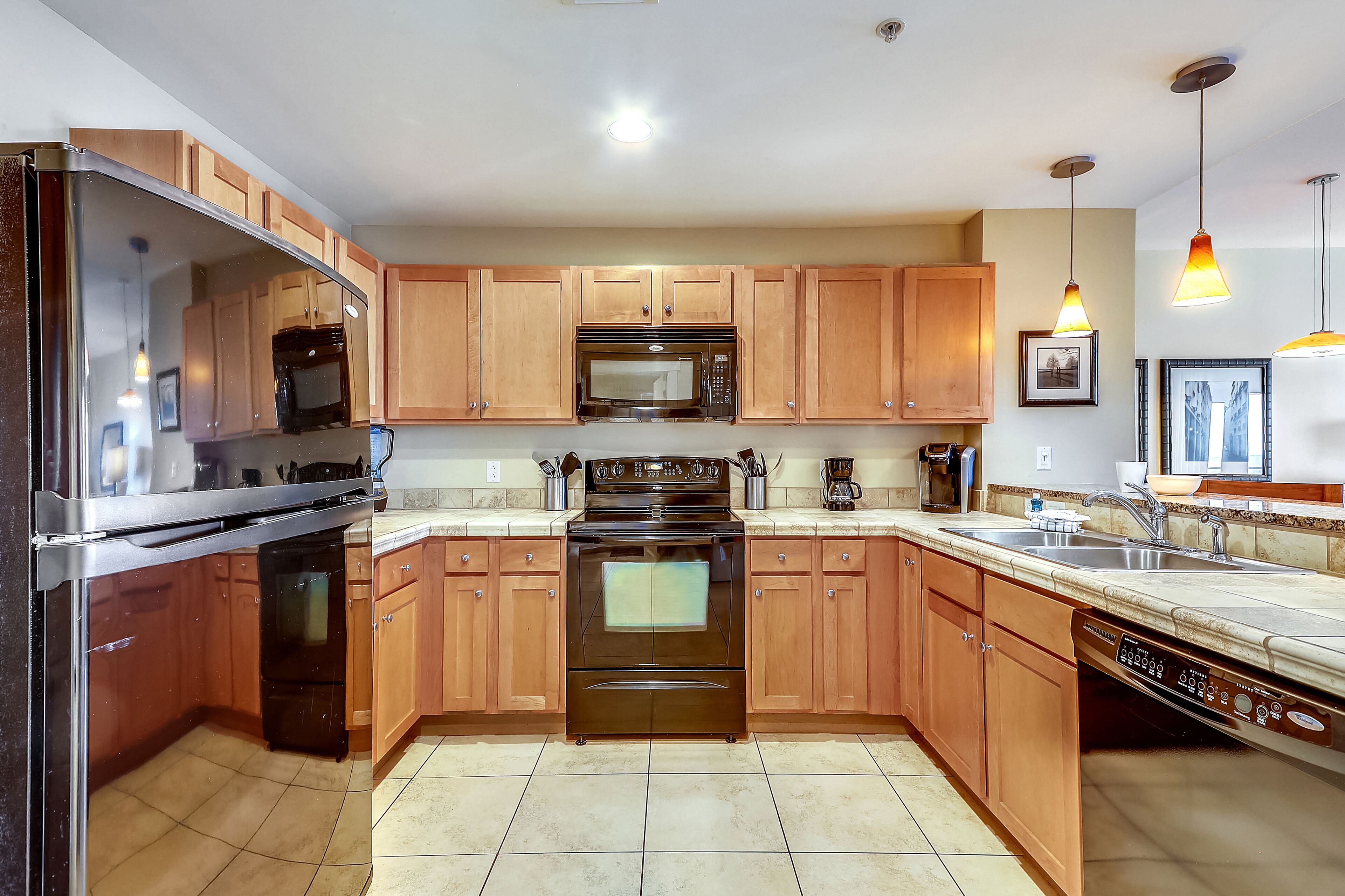 Una cocina moderna con armarios de madera, electrodomésticos de acero inoxidable y lavavajillas.