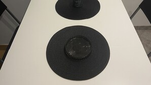 A white table with two black circular mats on it. - Studio ideally located and quiet 15 eme arrondissement (Paris)