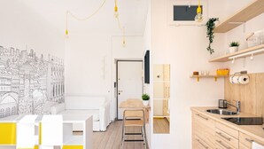 Eine moderne Küche mit Holzschränken, einem Spülbecken und einem Essbereich mit weißem Tisch und gelben Akzenten.