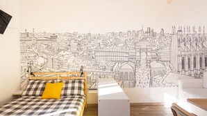 Ein Schlafzimmer mit einem Bett, einem Nachttisch, einer Wandmalerei einer Stadtansicht.