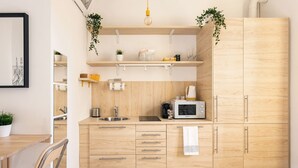 Eine moderne Küche mit Holzausstattung, einer Mikrowelle und hängenden Pflanzen.