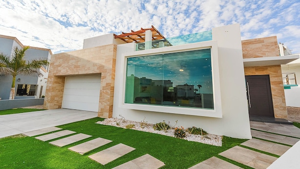 A modern house with a large glass window, a garage, and a well-maintained lawn. - Welcome to Your Perfect Beach Getaway F19, Welcome to Your Perfect Beach Getaway F19 (puerto penasco)