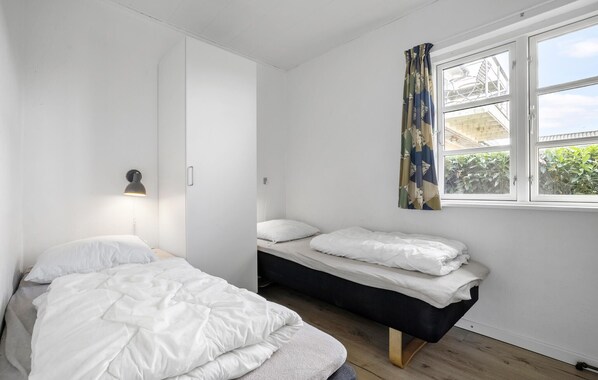 A bedroom with two beds, a window with curtains, and a wall-mounted lamp. - 2 bedroom gorgeous apartment in Hasle (Hasle)