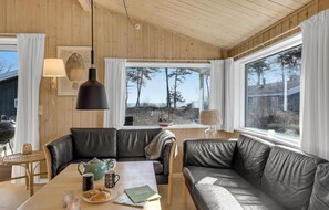 Relax in a serene space with a sofa, smaller couch, and wooden table, perfect for reading or unwinding.