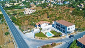 An aerial view of a residential area with a large house featuring a swimming pool, a road, and surrounding greenery. - Cozy apartment in Cava D'Aliga with WiFi (Cava D'Aliga)