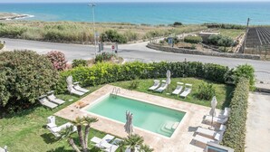 A pool area with lounge chairs and a view of the ocean. - Cozy apartment in Cava D'Aliga with WiFi (Cava D'Aliga)