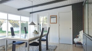 A modern kitchen with a large island, white cabinetry, and a view of the outdoors. - 3 bedroom amazing home in Nexø (Nexø)