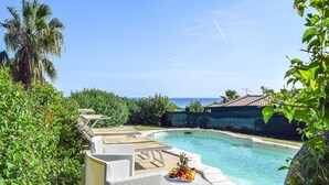 A pool area with lounge chairs and a fruit basket. - Nice home in Costa Rei with WiFi (Costa Rei)