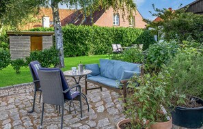 Relax in a serene outdoor space surrounded by lush greenery and a beautifully maintained patio.