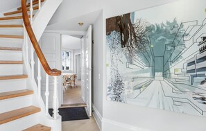 Staircase leads to a dining area with a table and chairs.