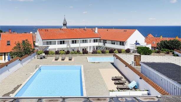 Ein Pool auf dem Dach mit Liegestühlen und Meerblick.