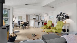 Ein modernes Wohnzimmer mit Kamin, Essbereich und Küche.