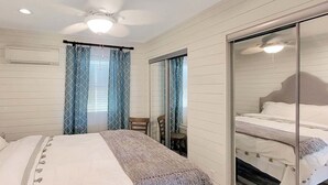 A bedroom with a bed, a chair, a table, and a mirror. - BAY-CAY Getaway, Beaching, Casinos, Swim, Grill, Chill, Memories! (Bay St. Louis)