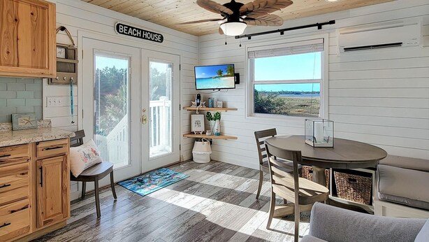 A beach house interior with a kitchen, dining area, and a view of the beach. - BAY-CAY Getaway, Beaching, Casinos, Swim, Grill, Chill, Memories! (Bay St. Louis)