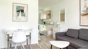 A compact living space with a dining area, kitchenette, and a gray sofa. - Amazing apartment in Nexø with sauna (Nexø)