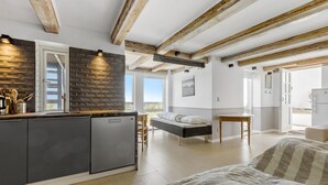 Eine moderne Küche mit Ziegelrückwand, Holzbalken und einem eingebauten Kühlschrank.