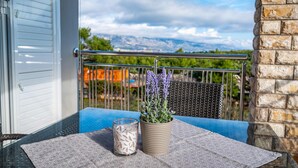 A balcony with a table, a potted lavender plant, and a candle. - Amazing apartment in Razanac with WiFi (Razanac)
