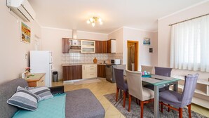 A compact living space with a kitchenette, dining area, and a small seating area with a sofa and chairs. - Amazing apartment in Razanac with WiFi (Razanac)