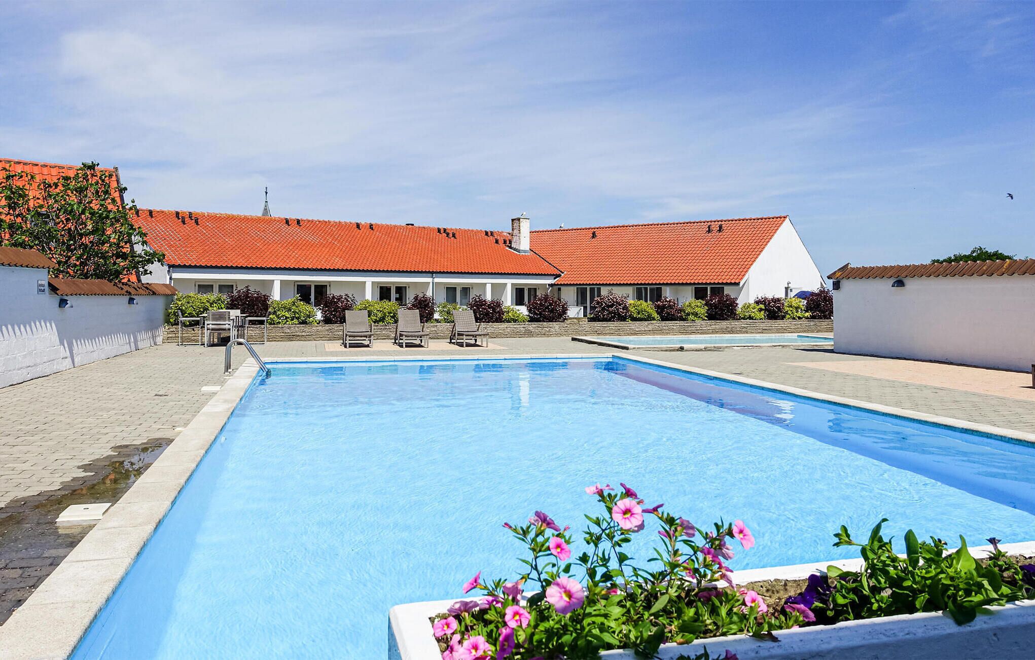 A swimming pool area with a building in the background.