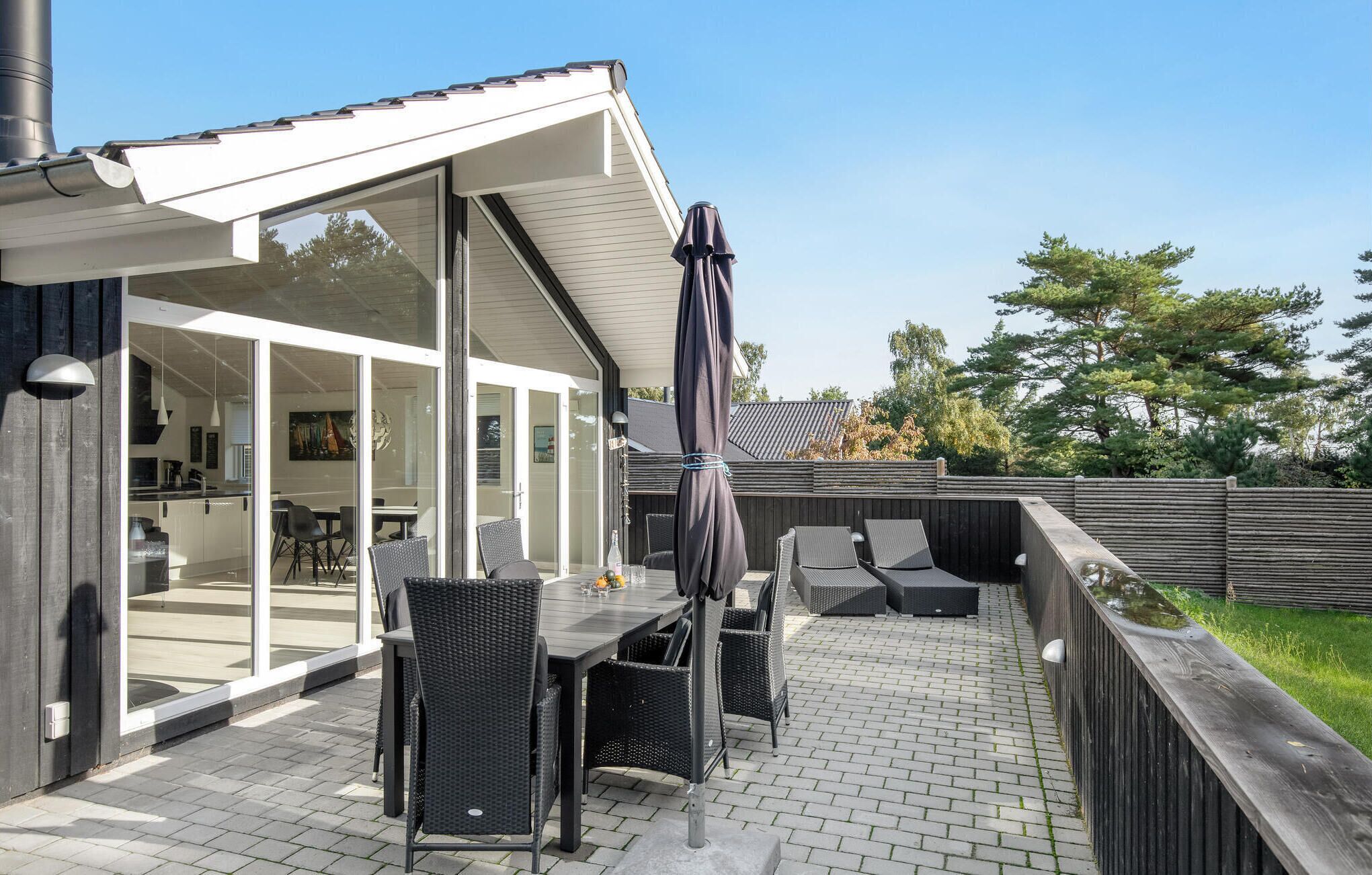 A patio with a table and chairs, a covered seating area, and a view into the house.
