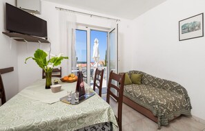 Enjoy dining and relaxation in this cozy space with a dining table, sofa, and comfortable chair.