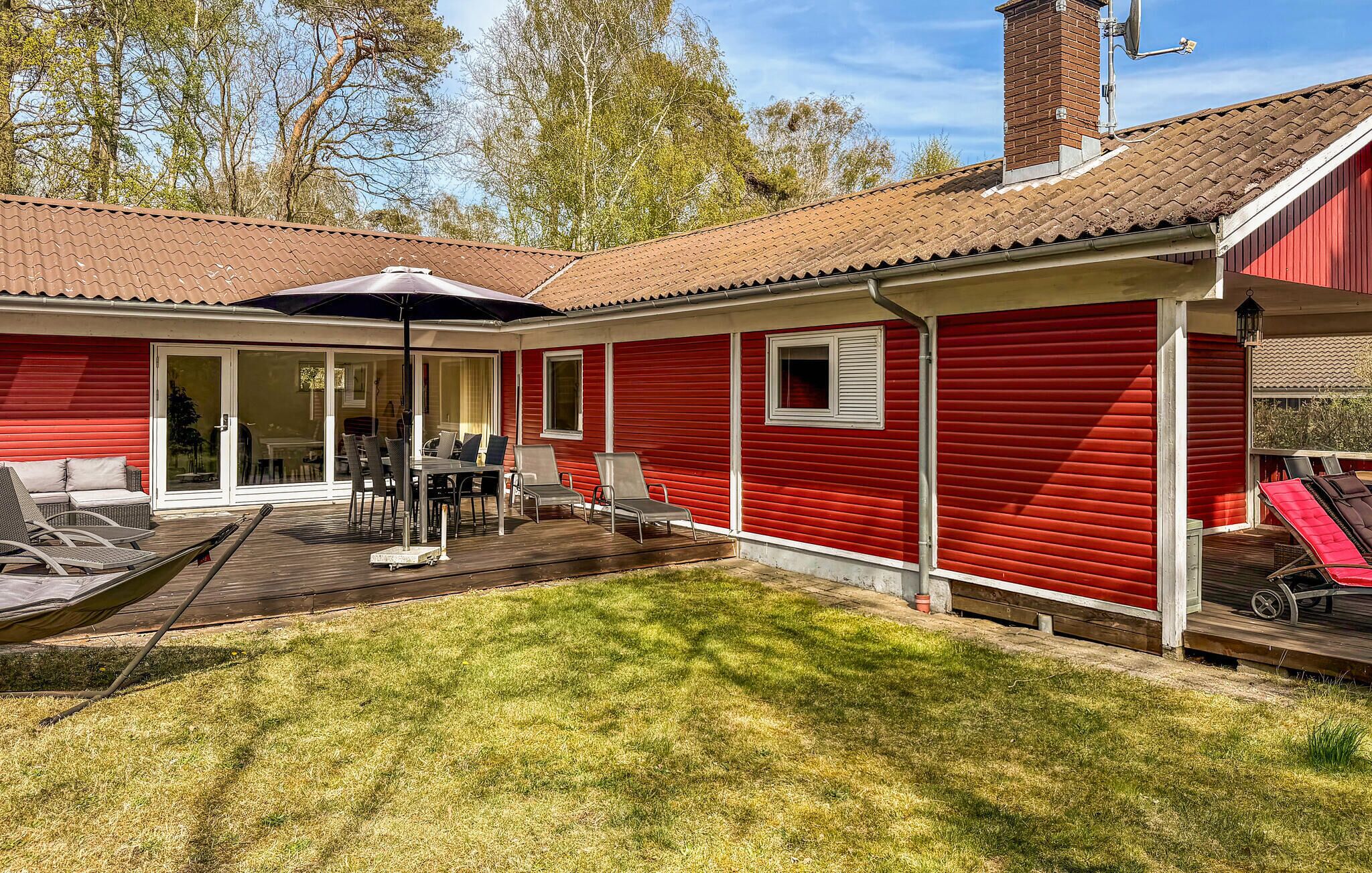 A red house with a patio, a sliding glass door, and a small window.
